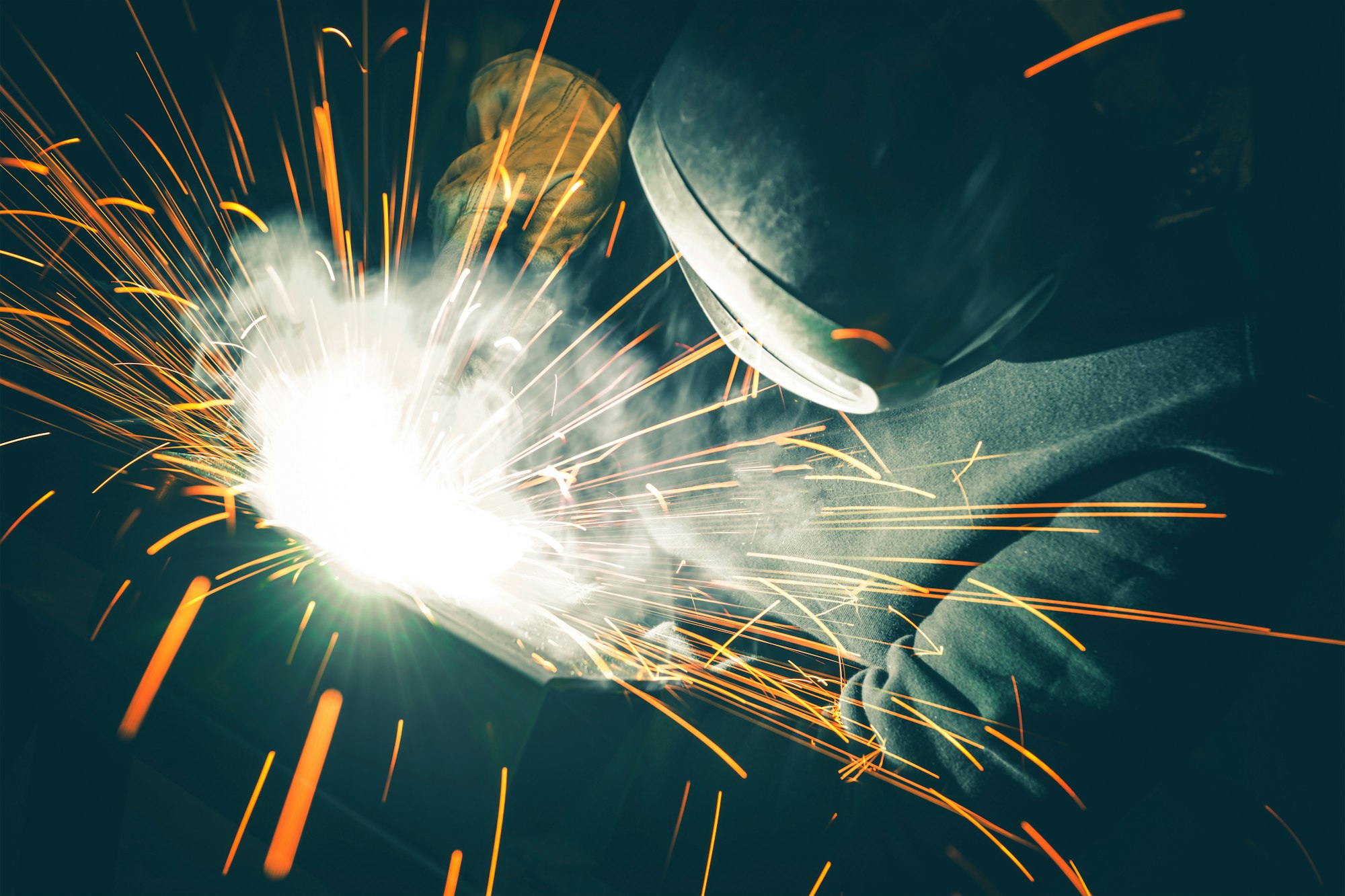 Welder is Welding Two Metal Parts Together